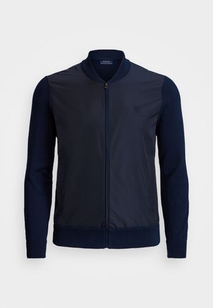 Granatowa męska kurtka bomber z zamkiem z przodu, ściągaczami przy mankietach i u dołu oraz subtelnym haftowanym logo Polo Ralph Lauren na piersi.