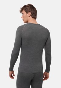 Thermounterhemd mit langen Ärmeln aus dunkelgrauem Stoff, mit figurbetonter Passform, rundem Ausschnitt und flachen Nähten für Komfort und Bewegungsfreiheit.
