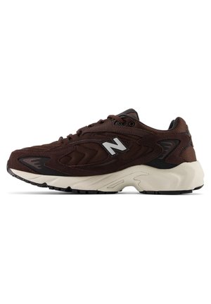 Baskets de sport marron foncé avec semelle blanche, dessus en mesh et en daim, fermeture à lacets, avec un logo blanc "N" sur le côté.