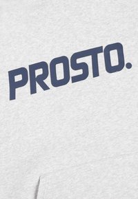 Szary sweatshirt z dużym granatowym logo "PROSTO." Materiał wydaje się miękki, o gładkiej teksturze i z kieszenią typu kangur.