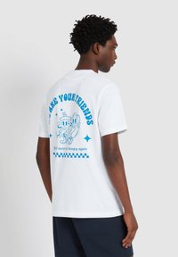 Witte katoenen t-shirt met een blauwe grafische print op de achterkant met cartoon voedselkarakters en tekst. Korte mouwen en ronde hals.