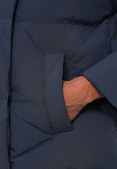 Tumesinine polsterdatud jakk, millel on pehme ja tekstuuriga viimistlus. Omab küljetaskut ja õmblustest kantimist.