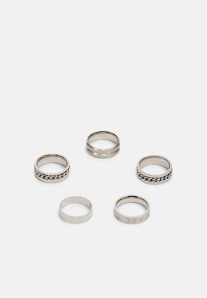 Conjunto de cinco anéis de prata com designs variados: um com padrão de corrente, dois lisos com bordas texturizadas e um com números gravados.