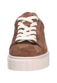 Bruine suède sneakers met platte witte veters, een ronde neus en een witte rubberen zool met textuur, voorzien van horizontale groeven voor grip.
