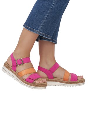 Pink and orange strappy sandals with a textured upper, adjustable buckle, and a white ridged sole. Flattened toe design for comfort.