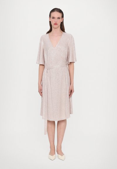 Vestido envolvente corto de manga corta en color rosa claro, con escote en V, que presenta una textura brillante y un lazo en la cintura. Llega hasta la rodilla.