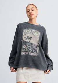Overmaat grijze sweatshirt, gemaakt van een katoenmix, met een kleurraf surfafbeelding van palmbomen en golven. Lange mouwen en een relaxte pasvorm.