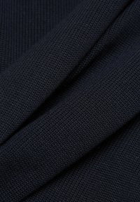 Marineblauwe textuurlijke stof met een gebreid patroon, met plooien en diepte, die de zachtheid en het weefsel van het materiaal benadrukt.