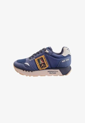 Sneaker blu navy con suola beige, lacci neri, patch ricamato delle Frecce Tricolori, testo "Aeronautica Militare" e "MB 339" sul lato e sul tallone.