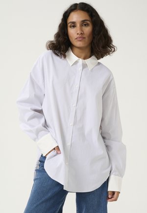 White striped shirt with a collared neckline, long sleeves, and button front. Features contrasting white cuffs and a relaxed fit.