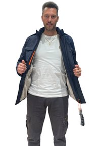 Giacca imbottita blu navy con interno texturizzato, chiusura frontale con zip e dettagli arancioni. Caratterizzata da tasche laterali e collo regolabile.