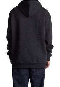 Sweatshirt noir à capuche avec une coupe décontractée, confectionné en tissu doux. Il possède des manches longues et un ourlet côtelé. Détail de couture visible.