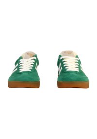 Sneaker in suede verde con lacci bianchi, caratterizzate da una suola in gomma marrone e un logo sulla linguetta. Strisce laterali bianche aggiungono un tocco di dettaglio.