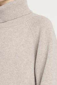 Maglione a collo alto grigio chiaro con colletto a costine e tessuto morbido e strutturato. Presenta maniche raglan e una vestibilità rilassata.