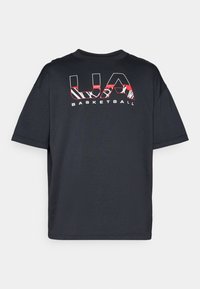 Sort kortærmet t-shirt med en afslappet pasform, med rød og hvid grafisk tekst "UA BASKETBALL" på fronten. Blødt stof.