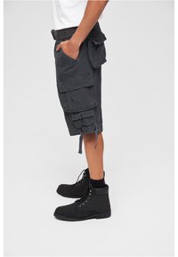 Gray cargo shorts with multiple pockets, drawstring hems, and a relaxed fit, paired with black ankle boots and dark socks.