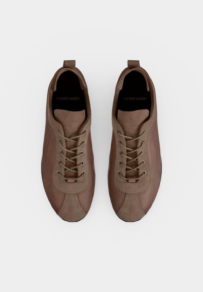 Paire de chaussures décontractées marron à lacets avec bouts arrondis et languettes pour tirer, vues de dessus sur un fond clair uni.