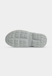 Semelle de chaussure gris clair vue de dessous, avec un motif antidérapant texturé et le mot "superfit" embossé au centre.