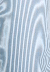 Tessuto a strisce blu chiaro e bianco con sottili linee verticali; superficie liscia e pattern coerente su tutta la superficie.