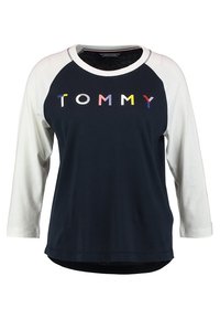 Navy cotton t-shirt with white raglan sleeves, featuring multi-colored "TOMMY" text across the chest. Smooth texture, rounded hem.