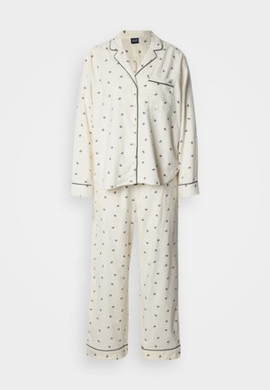 Kremowy komplet piżamowy z miękkiego materiału, zdobiony rozmieszczonym wzorem kwiatowym, kontrastową lamówką, kieszenią na piersi oraz długimi rękawami zakończonymi mankietami na guziki.