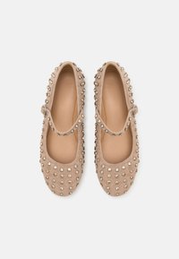 Beige semsket Mary Jane-sko med rund tå, prydet med metallnagler, med justerbar stropp og glatt innerfor.