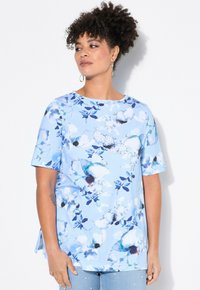 Top de manga corta azul claro con un estampado floral en tonos de azul y blanco, con cuello redondo y aberturas laterales.