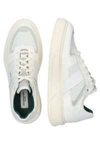 Witte sneakers met een bovenwerk van mesh en leer, geperforeerd ontwerp, ronde neus, witte veters en groene interieurdetails. Dikke zool.