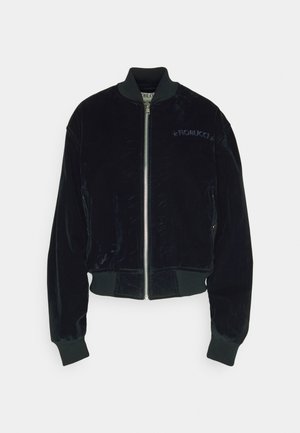 Jachetă bomber din catifea neagră cu manșete și tiv ribbed, fermoar frontal argintiu și logo-ul brodat "Fiorucci" pe partea stângă a pieptului.