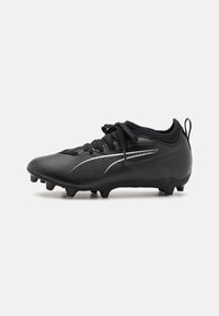 Botas de fútbol negras con una parte superior texturizada, cierre de cordones y un acento plateado. Presenta una suela firme con tacos para tracción en el césped.