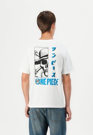 T-shirt en coton blanc avec un grand motif noir et bleu représentant un crâne avec un chapeau et des os croisés, accompagné de texte japonais. Coupe décontractée.