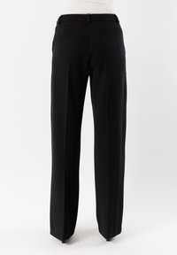 Pantaloni neri su misura con design dritto, parte anteriore liscia e passanti per cintura. Realizzati in un tessuto leggero e morbido.