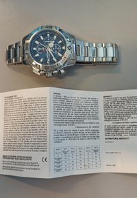 Orologio in acciaio inox argentato con quadrante blu, funzionalità cronografo, indicatori luminosi e bracciale in metallo coordinato. Include manuale di istruzioni.