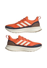 Scarpe da ginnastica arancioni con tre strisce bianche, tomaia idrorepellente e suola blu navy a contrasto. Presentano un design a rete testurizzata e un'etichetta per il tiraggio.