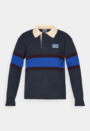 Polo majica iz volnene mešanice v mornarsko modri barvi s kremnim ovratnikom, z vodoravnimi črtami v modri in maroon barvi ter manjšim logotipom na levi strani.