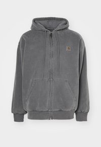 Szara bluza z kapturem na zamek, wykonana z miękkiego materiału, z kapturem na sznurki, przednimi kieszeniami oraz małą naszywką z logo na górnej lewej stronie.