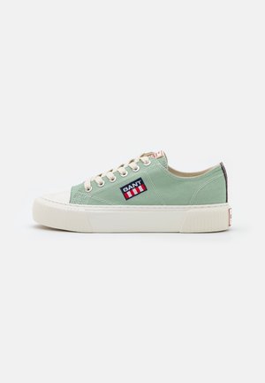 Hellgrüner Canvas-Sneaker mit niedrigem Schaft, weißer Gummisohle, cremefarbenen Schnürsenkeln und GANT-Logo-Patch an der Außenseite, gezeigt von der Außenseite.