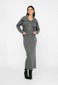 Grå stickad tvådelad outfit med en krage, knäppt topp med två fickor och en matchande lång kjol med sidoknappsal detalj.