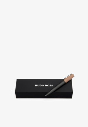 Crni kemijski olovka s teksturiranim držanjem i smeškim naglascima, postavljena pored crne kutije s bijelim logotipom "HUGO BOSS".