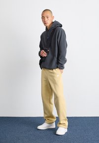 Nike Sportswear CLUB PANT - Tepláky - team gold