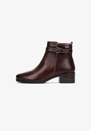 Bottine en cuir marron au design élégant, avec un talon block de hauteur intermédiaire, un accent à boucle et des détails de coutures contrastées.