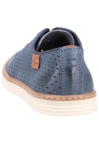 Chaussure en cuir perforé bleu marine avec semelle claire et accents marron clair, forme arrondie et détails surpiqués. Conçue pour un usage décontracté.