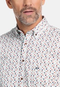 Overhemd met knoopsluiting in een wit, blauw en rood vierkant patroon. Heeft bruine knopen en een klein logo op de borst. Gemaakt van katoen.