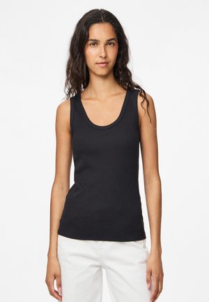 Sort ribbet tanktop med en dyb udskæring og brede skulderstropper. Stof virker blødt med en tætsiddende pasform. Velegnet til lag-på-lag eller som selvstændigt tøj.