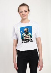 Bílý bavlněný tričko s grafickým potiskem osoby s pletenými vlasy a textem "SHIMMY SHIMMY YA!" tučným černým písmem.
