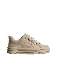 Beige velúr sneaker, kerek orral, textúrált panelekekkel, vastag talppal és fűzős dizájnnal. A könnyű felhúzást szolgáló hátsó húzófüllel rendelkezik.