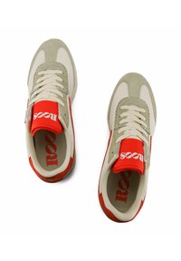 Sneaker beige e rosse realizzate in materiali scamosciati e in rete. Presentano una punta arrotondata, chiusura con lacci e dettaglio del logo interno.