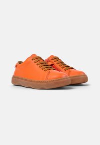 Zapatillas de cuero naranja con cordones marrones y cremallera lateral, que cuentan con una suela de goma redondeada con detalles texturizados.