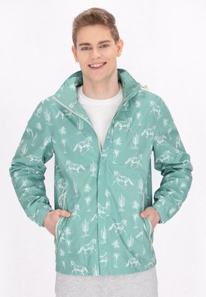 Licht turquoise jack met witte patronen van een paard en cactus, met een ritssluiting aan de voorkant, hoge kraag en zijzakken. Luxe, waterafstotend materiaal.