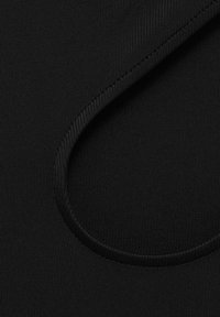 Tejido elástico negro con una textura suave, que presenta un corte circular a lo largo del borde, destacando su diseño y forma flexibles.